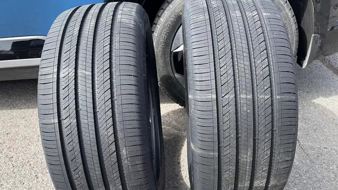Close-up of two EV tires tread pattern on a paved surface